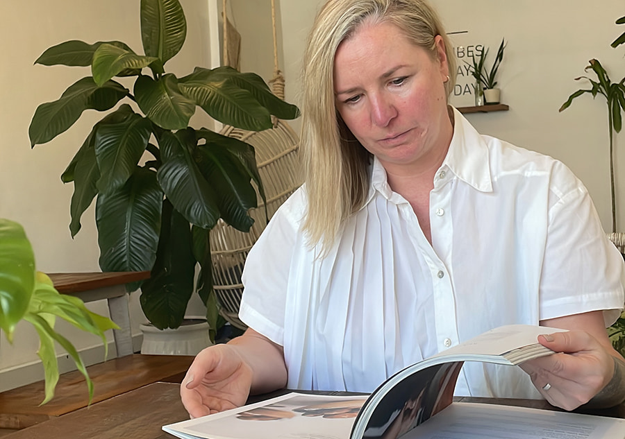 Emma Fountain, Founder of Backyard Cafe, reads at a table